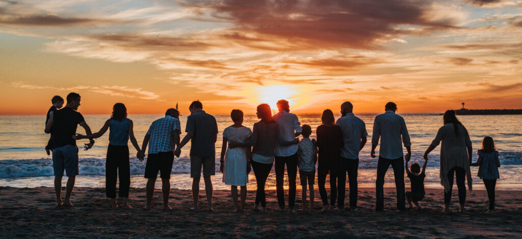 Family watching the sunset at the same time on a beach